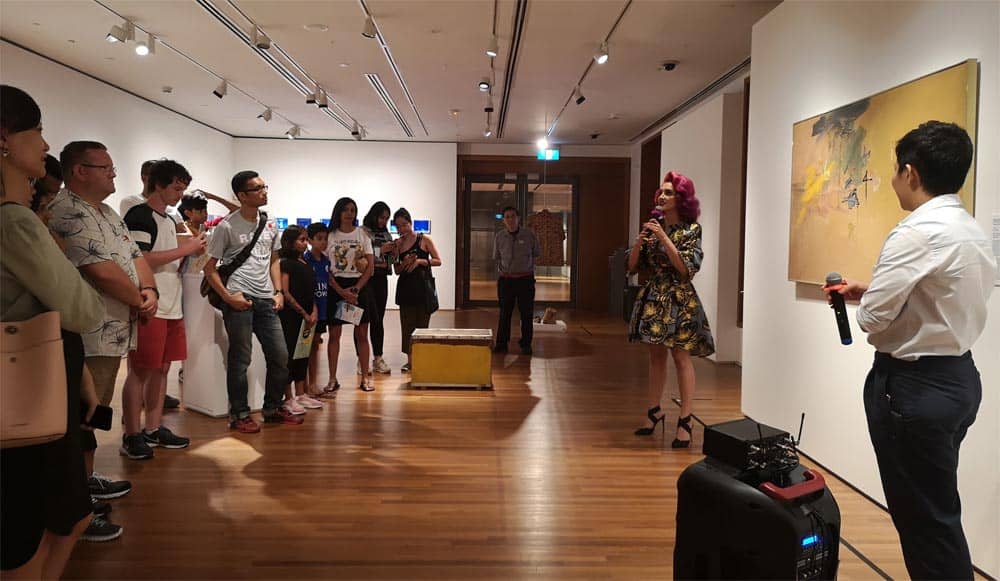 Celebrity Sukki Singapora providing her opinions on rebellion and repression in the scribbled digits of Suzann Victor’s Yellow Ochre Digits at the National Gallery Singapore.