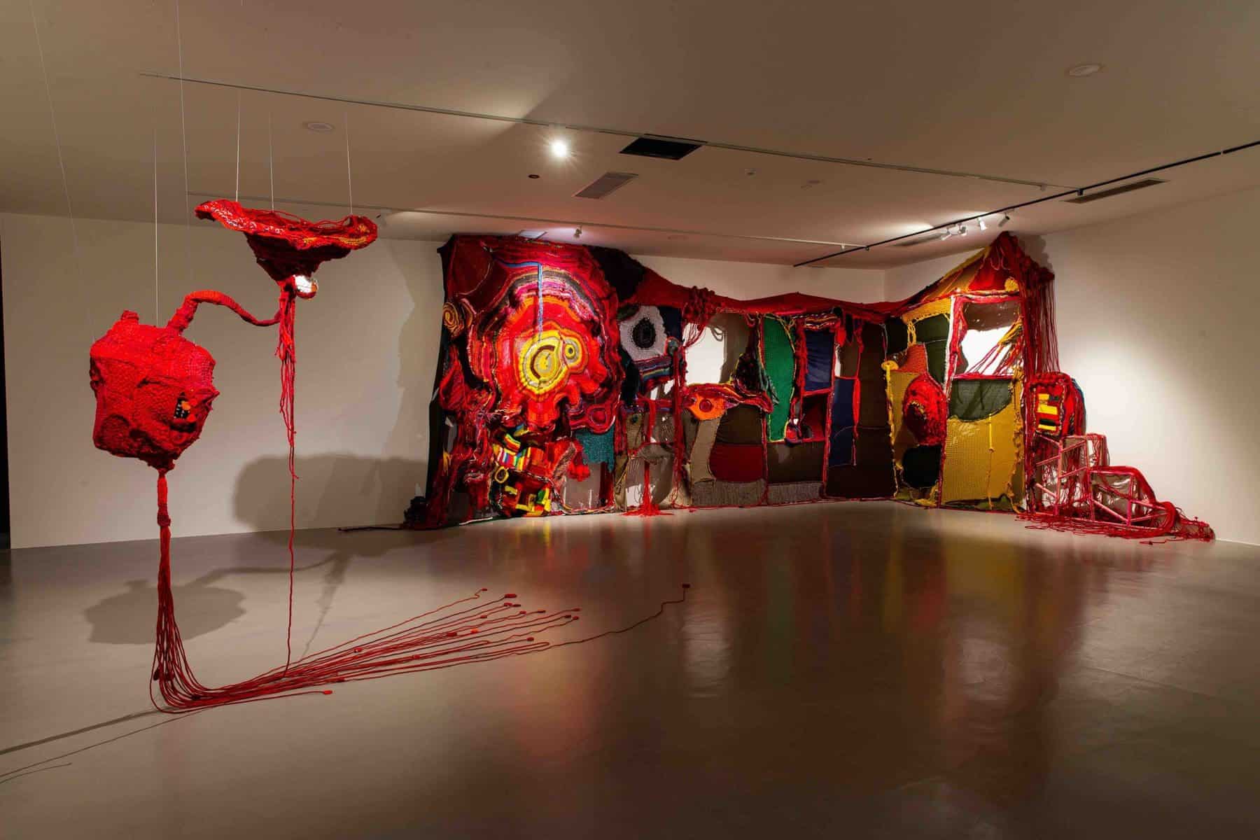 (Right) Aruwai Kaumakan, Vines in the Mountains, 2020, wool, ramie, cotton, copper, silk, glass beads, dimensions variable. (Left) Aruwai Kaumakan, The Axis of Life, 2018, recycled fabric, cotton, organic cotton, 500×120×100 cm
