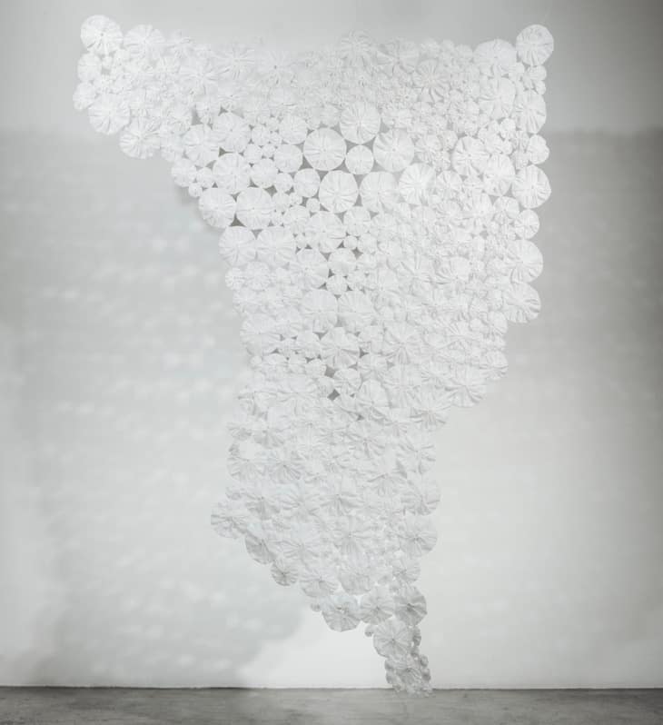Ade;ine Kueh artwork - a rosette table runner that is porous and features shapes, stripped of color to convey a message. 