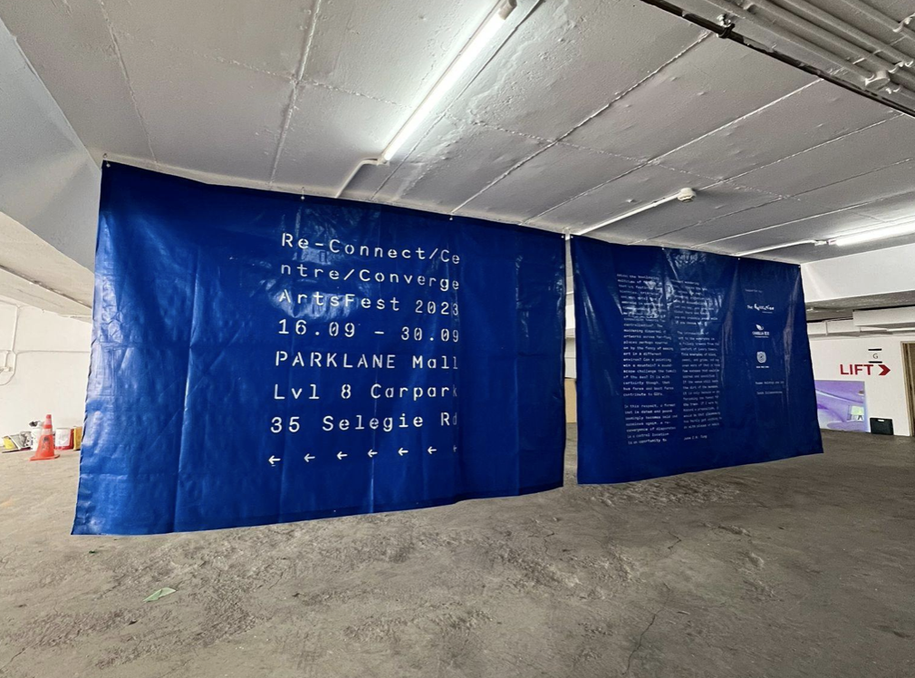 Exhibition text on blue tarpaulin at the entrance of the festival. Image Courtesy of Nicole Phua