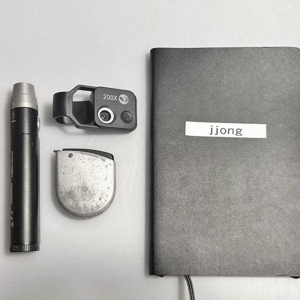 Some of Jefferson Jong's trusty tools, featuring a pen, UV light, zoom lens, measuring tape, and notebook. Image credit: Jefferson Jong.