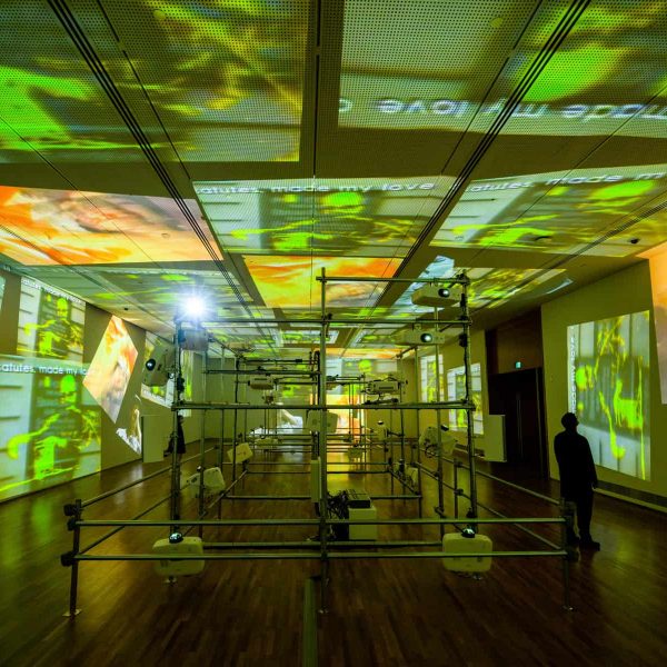 Technological hardware often plays a sculptural role in Paik’s installations — the projectors and scaffolding are as much a part of Paik’s Sistine Chapel (1993, reconstructed 2021) as the flickering images on the wall. Image courtesy of National Gallery Singapore.