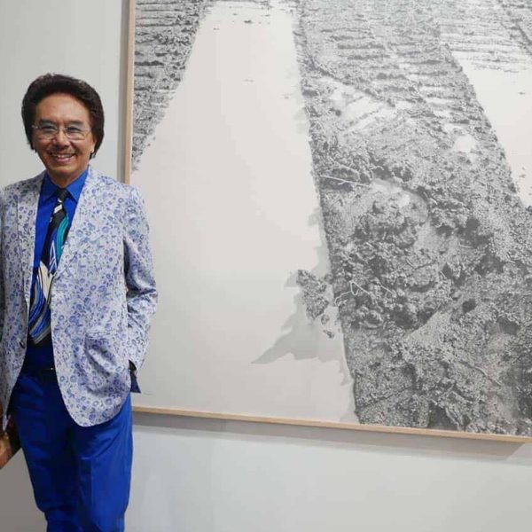 Pak Deddy, standing with the work "A Minute Rain," by Bambang BP